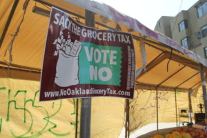 Outside of Mi Carnal Market, Abdul Talev hangs a "Vote No" sign.