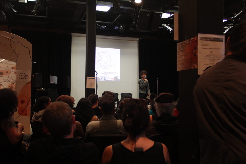 Erin McElroy, co-founder of the Anti-Eviction Mapping Project, welcomes guests to the presentation of the oral history map.