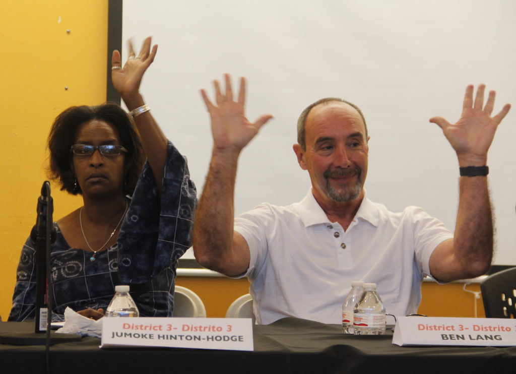 Director Jumoke Hinton Hodge and Ben Lang, both of District 3, wave to the audience at Lighthouse Community Charter School Tuesday night.
