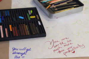 Attendees of the Depressed Cake Shop pop-up event in Oakland wrote encouraging notes on a butcher paper-covered table.