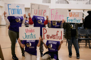 Students from Lionel Wilson College Preparatory hold up signs while they attend the school's charter renewal at this week's school board meeting. Photo by Rosa Furneaux.