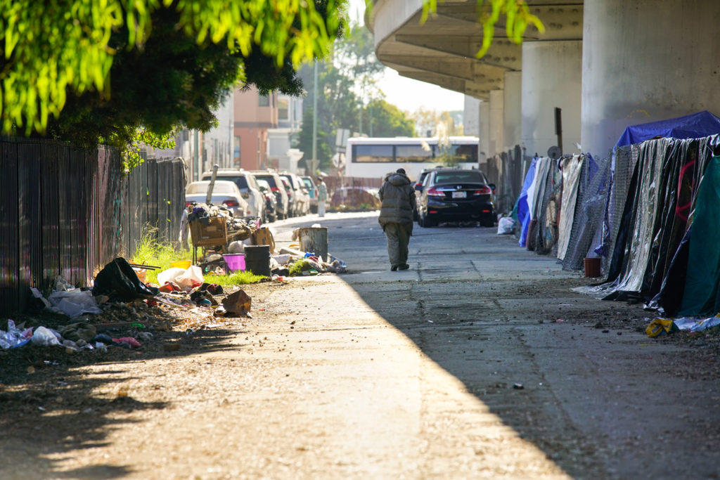 A homeless man walks towards a tent in a encampment behind the Chinese Garden Park in Oakland on Saturday, October 1, 2016. (Yesica Prado/Oakland North)