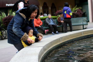 A mom is leading her kid to the fountain to see carps. Photo by Tian Chenwei.