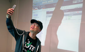 Roger Saechao, 25, taking a selfie of the big soda tax campaign winning percentage in Oakland. Photo by Nani Walker.