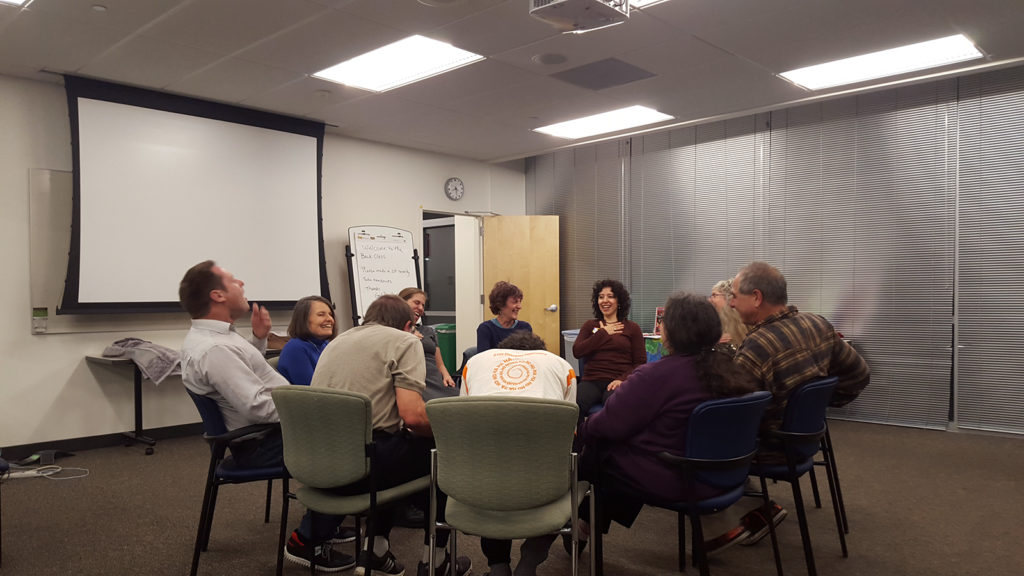 Participants whoop and giggle during an exercise in a laughter yoga class in Oakland. Some came to this class in part to relieve election-related stress.