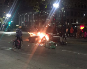 Trash on fire at the demonstration in downtown Oakland. Photo by Misyrlena Egkolfopoulou.