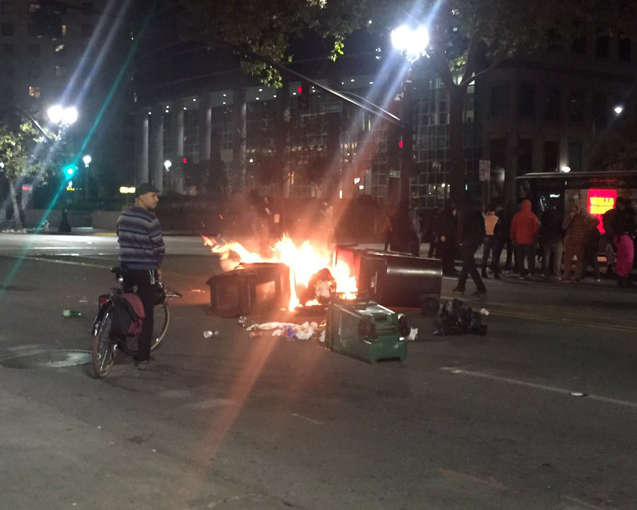 Trash on fire at the demonstration in downtown Oakland. Photo by Misyrlena Egkolfopoulou.