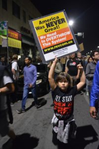 A child marches in Oakland with fist and sign in the air. Photo by Sawsan Morrar.