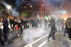 Tear gas canisters drop into a crowd on Broadway and protesters disperse. Photo by Jacob Shea.