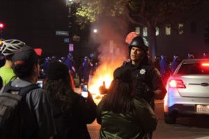 An officer speaks calmly with onlookers, many of whom were filming or photographing. Photo by Jacob Shea.
