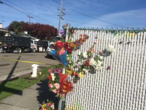 Mourners began to leave flowers along the fences near the warehouse site. Photo by Sonner Kehrt.