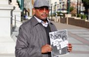 Gregory Lewis holds up a childhood photograph of himself campaigning for Bobby Seale. Lewis, who now works as a lawyer in downtown Oakland, attributes the Oakland Community School with much of his success.
