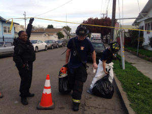 Firefighters leaving the scene of the warehouse fire with bags of gear. Photo by Rachel Cassandra.