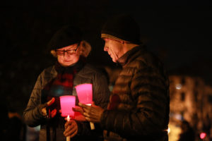 Two community members light candles to grieve the lives lost in the tragic "Ghost Ship" fire, Photo by Khaled Sayed