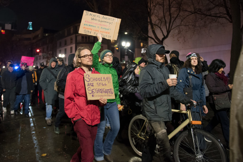 Protesters march along Broadway with signs. Photo by Rosa Furneaux.
