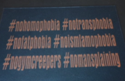 A sign saying "#nohomophobia #notransphobia #nofatphobia #noislamophobia #nogymcreepers #nomansplaining" at Oakland's Queer Gym. Taken from the video by Angeline Bernabe and Jackeline Luna.