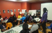 Urban Peace Movement's youth member Joel Reyes facilitates a chess lesson for DetermiNation Black Men's Group. Photo by Prince White.
