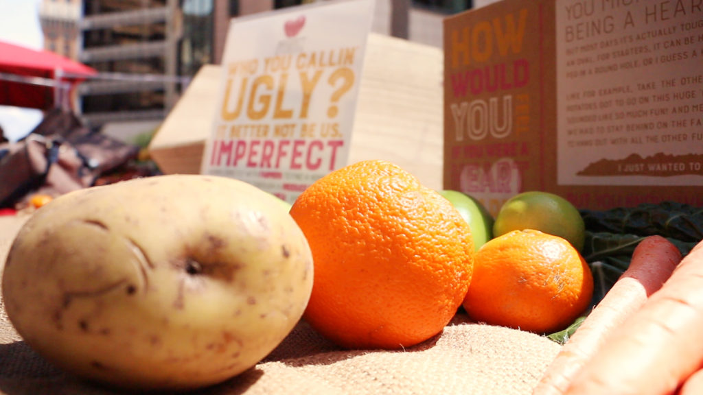 Imperfect Produce is a start up company with a mission to end food waste. On Tuesday, April 19, Oakland residents signed up for their services at Vivian's booth as part of an Earth Day celebration at the Oakland City Center. (Aileen Macalintal | Yesica Prado/Oakland North)