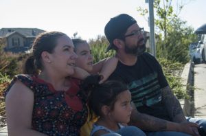 The Castillo family (left to right in back) Tracy, Sophia, Ernie and Samantha (front) watch as fire crews battle a four-alarm fire in the Oakland hills on Tuesday. "I don't even know if it's safe to stay here tonight." Photo by Drew Costley