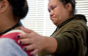Teddie Moorehead, 40, places her hand on her daughter Che-Kwis Hernandez, 12, who spoke to a room full of East Oakland residents about her experiences as a witness to sex trafficking in her neighborhood. Photo by Lisa Hornak