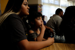 Residents, including Maria Cruz, 20, and her daughter Destiny Cruz, 4, met to discuss issues facing East Oakland, part of the launch of the first annual East Oakland Congress of Neighborhoods assembly at the International Community School on International Boulevard. Photo by Lisa Hornak