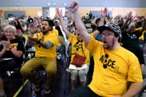 Far right, Kelby Peeler, 30, and other residents and organizers cheered after committing to an agenda that will be made public during a rally on November 7th in front of City Hall. Photo by Lisa Hornak