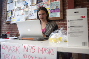 J Redwoods, a trans and disability activist who uses “they” as their preferred pronoun, coordinates distribution of respiratory masks at Impact Hub, a co-working space in downtown Oakland. Redwoods said they used $350 of their own money to buy masks and hand them out to people in the streets.