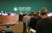 Community members file to the podium to voice concerns to the OUSD school board. Photo by Hyowon Lihinag-Tam.