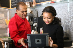 Speaking Amharic with Roberto, Tamirue guides him through the Grubhub application on the tablet. Tamirue was born and raised in Oakland. Her mother and Roberto come from the same generation in Ethiopia.