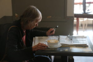 Bonnie Wilder, a retired from an accounting firm, is one of the only customers at Enssaro Café who doesn’t take out a device. She spends more than an hour enjoying her latté and The New York Times.
