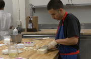 A chef at the Town Kitchen in Oakland cuts through blocks of tofu.