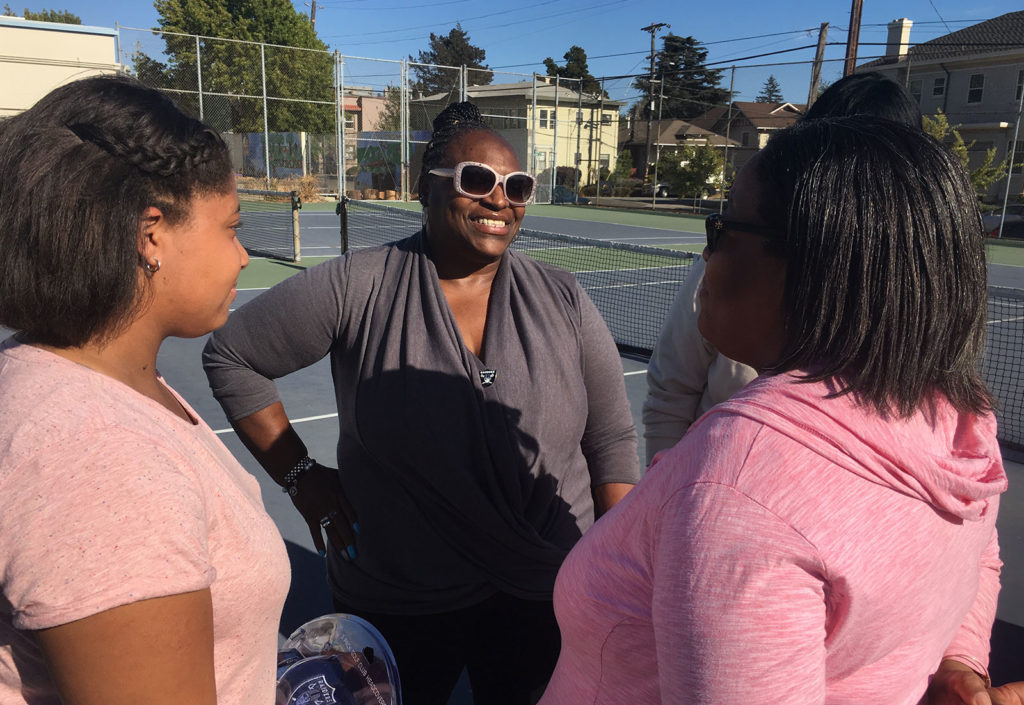 Delisa Lynch, mother of RB Marshawn, encourages Edana Anderson, mother of student golfer Hannah.