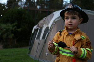 A firefighter ensures that all the tents are up to safety code. Just kidding—he’s a child.