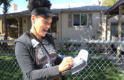 Donna Anderson marks on a map the house number she just visited in Sobrante Park as she makes her way through the neighborhood Saturday morning.