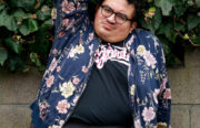 Caleb Luna, an apple-shapped fat femme, poses outside of their home in West Oakland.