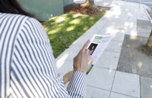 Marlo Rodriguez handing out her flyer to passerby. Photo by Shuang Li.