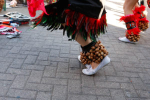 Two traditional Aztec dancers add percussion to the group dance through ayoyotes worn on their ankles.