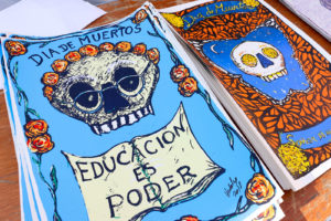 A table nearby features screen prints by Gonzalo Hidalgo. One poster reads, “Educacion es poder,” or “Education is power.” Another reads, “Soñar es un Derecho,” or “To Dream is a Right,” the title of his installation.
