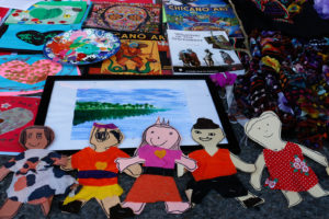 Altamirano's altar, titled “Mother Earth Loves Us All,” features art provided by Ramirez-Garcia’s students. The dresses are Ramirez-Garcia’s, who added them to symbolize the drowning of children—angelitos—during the Syrian refugee crisis. Garlic was meant to ward off bad spirits, and beans to provide guidance.