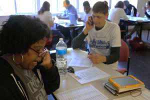 “Today is Election Day, and I’m just calling to make sure you voted,” says Cherri Murphy (left) as she calls an undecided voter from a paper list given to her at Brooks’ campaign headquarters. At the same time, Michael Cross (right) checks off another call on his list.