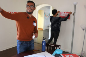 Tausif Khan (left), an intern on Schaaf’s reelection campaign, hands a piece of tape to another intern as the group decorates her campaign headquarters for Tuesday’s results watch party.