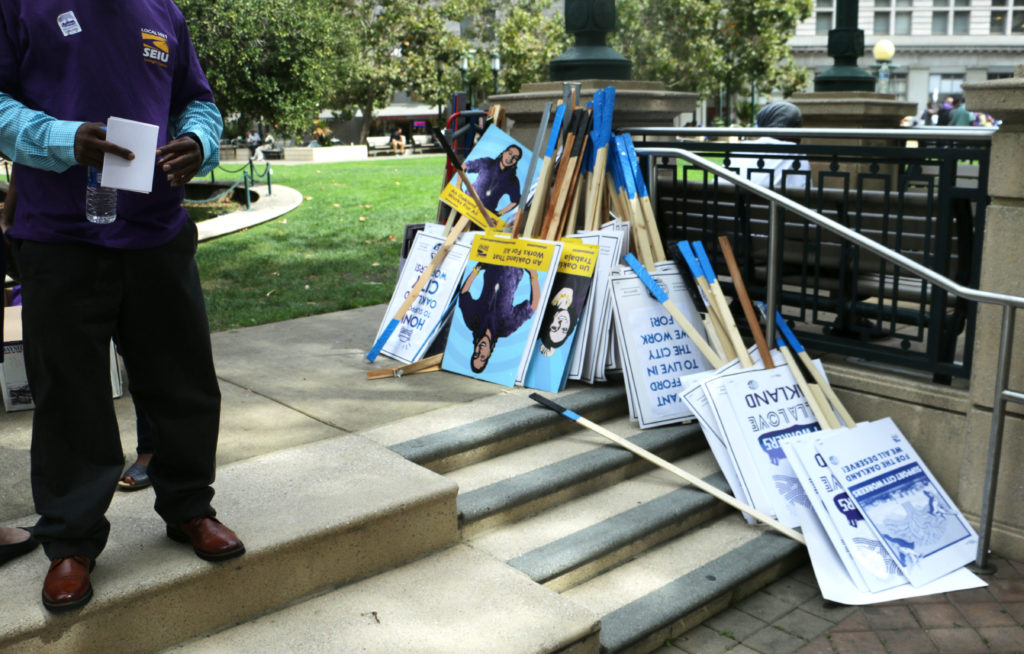 A pile of picket signs, stacked on steps near Frank Ogawa Plaza.