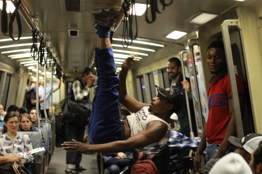 Turfer Christopher "Carmu" Davis hangs upside down by his feet during a set on BART between Embarcadero and West Oakland BART stations. Photo by Jocelyn Tabancay