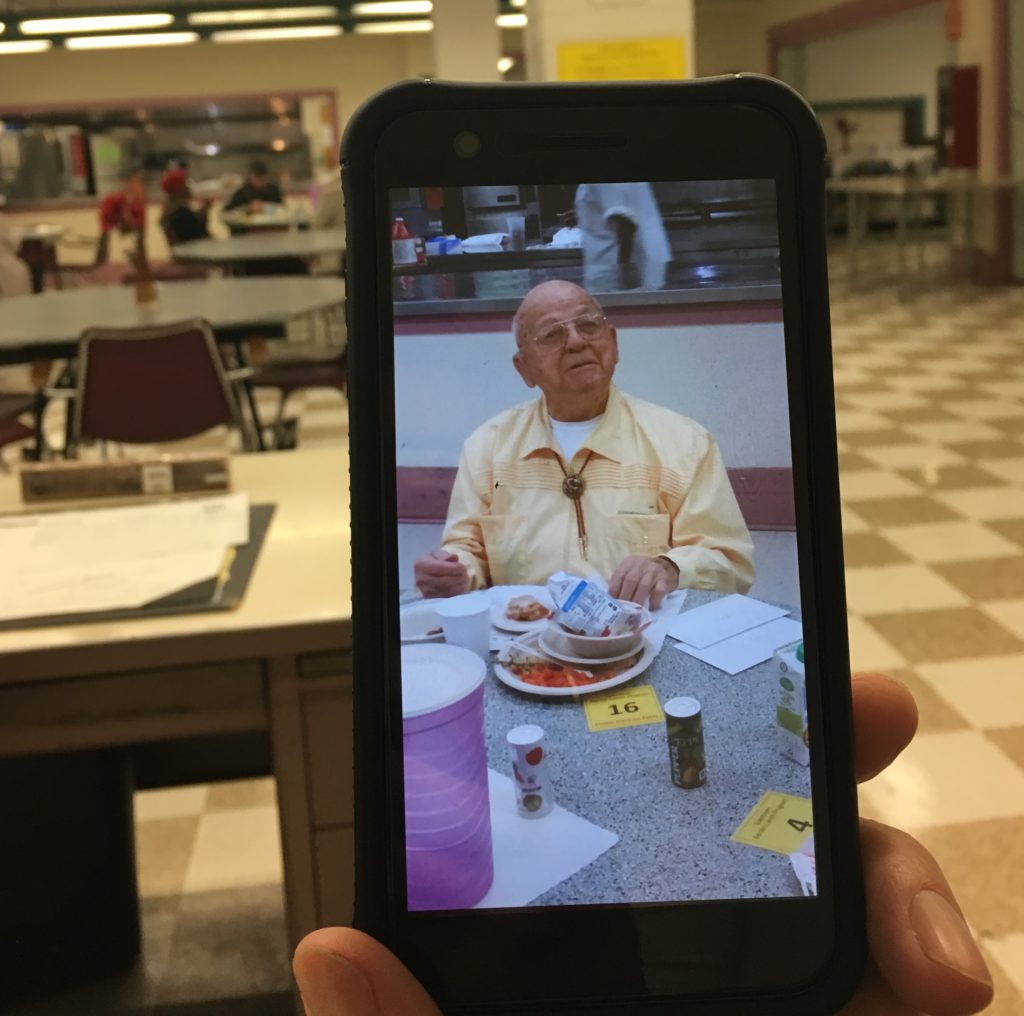 Sosa's photo, displayed on his iPhone, of the 100-year old man on his birthday at the Downtown Oakland Senior Center meal, with his plates of finished food in front of him.