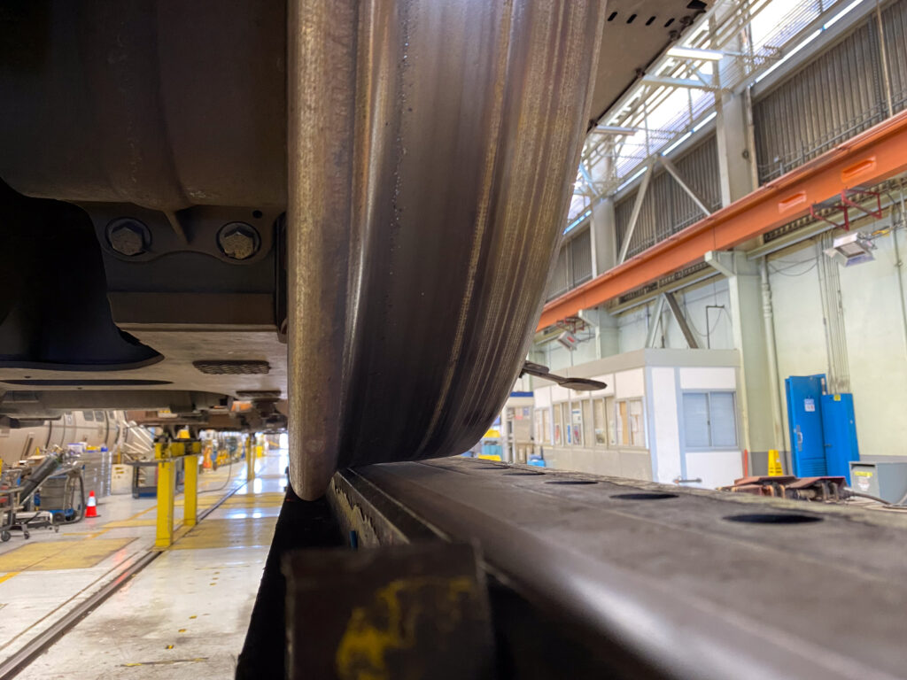 Closeup of a steel BART train wheel flush against the track in the Richmond maintenance shop.