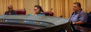 Sitting at a curved table looking somber are members of the Oakland Police Commission from left, Rudolph Howell, Tyfahra Milele, and David Jordan at the Sept. 28 town hall