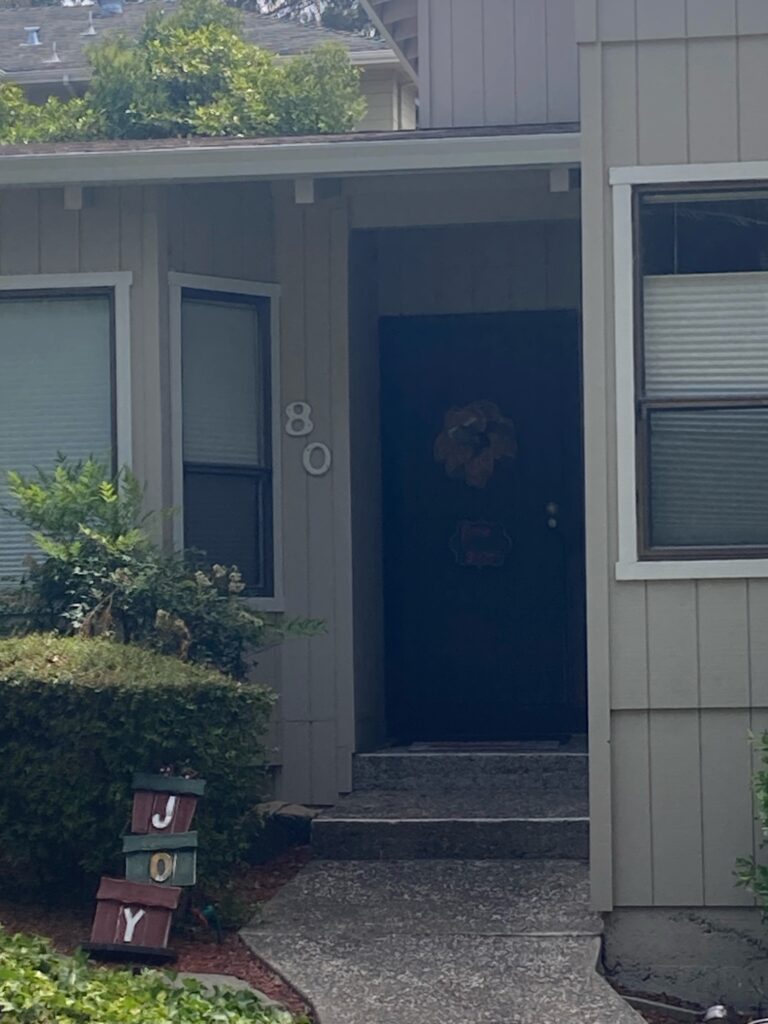 Front door with the numbers 80 visible and blocks that spell out JOY