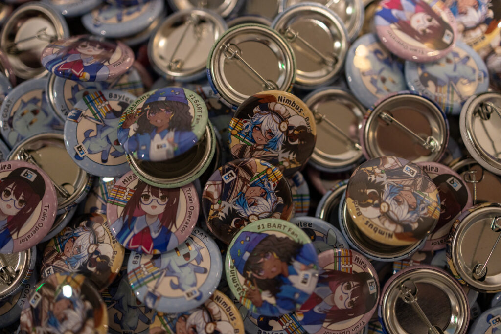 A pile of buttons with different anime characters on them.