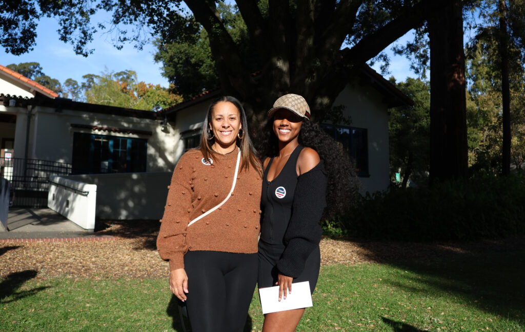 A mother and Daughter smiling in the warm Oakland sun after voting.