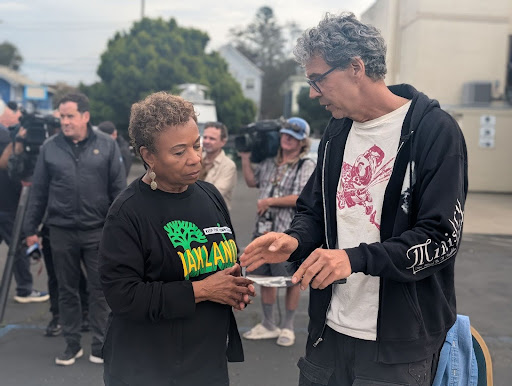 Oakland mayor Barbara Lee speaks with blacksmith John Rogers.